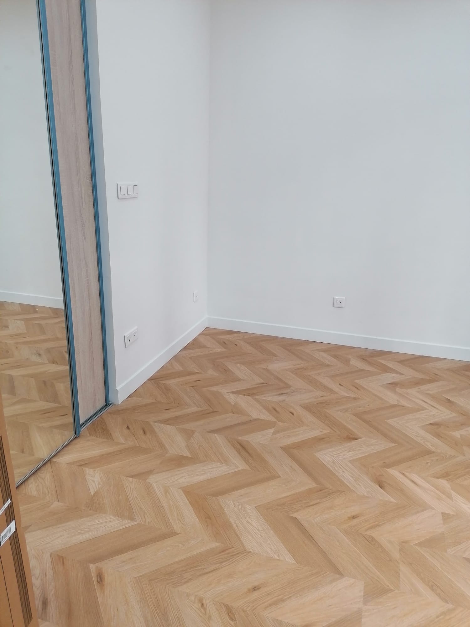 Pièce de vie rénovée avec parquet chevron et spots encastrés