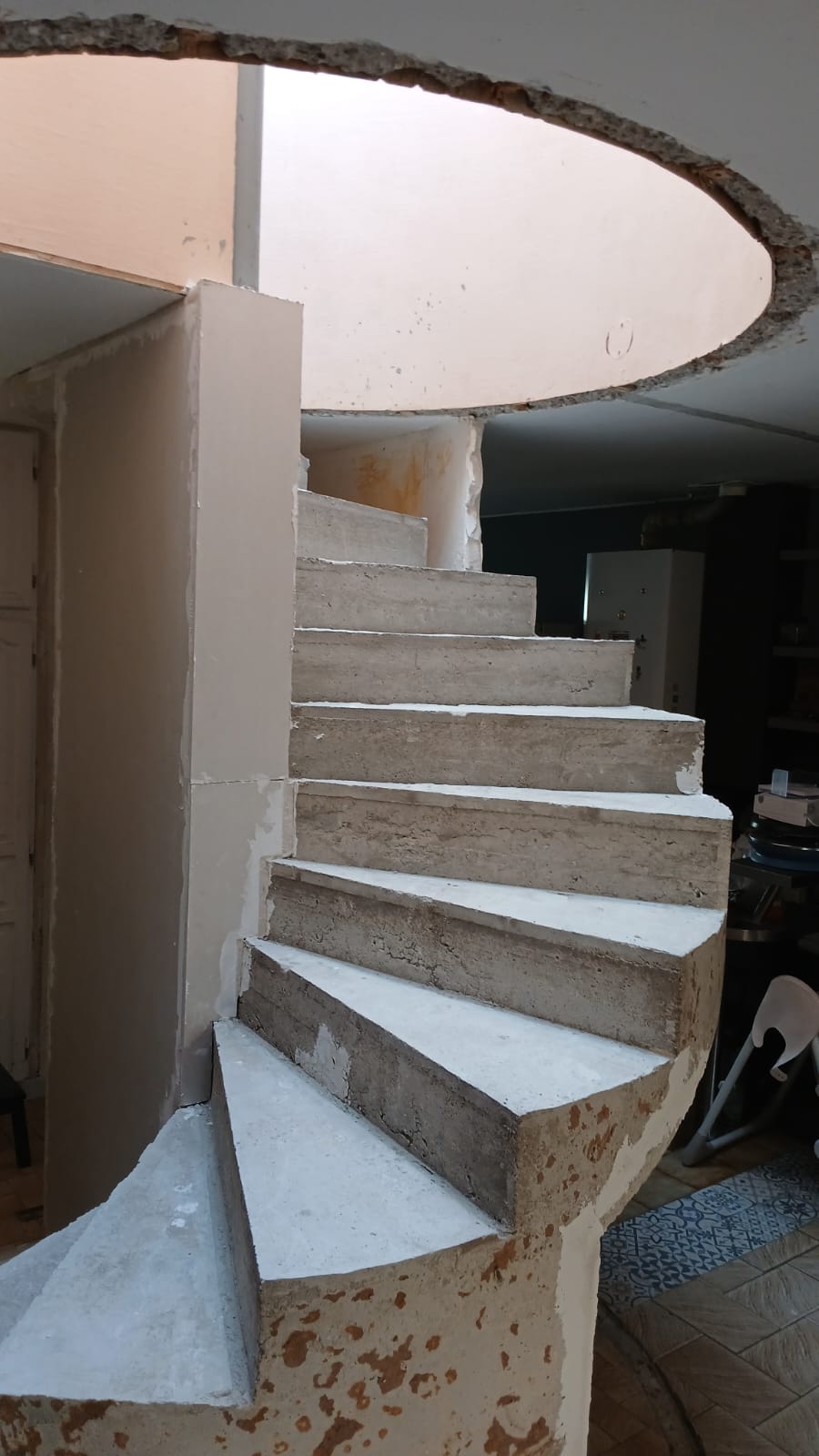 Détail des marches béton et de la trémie arrondie de l'escalier terminé en Essonne