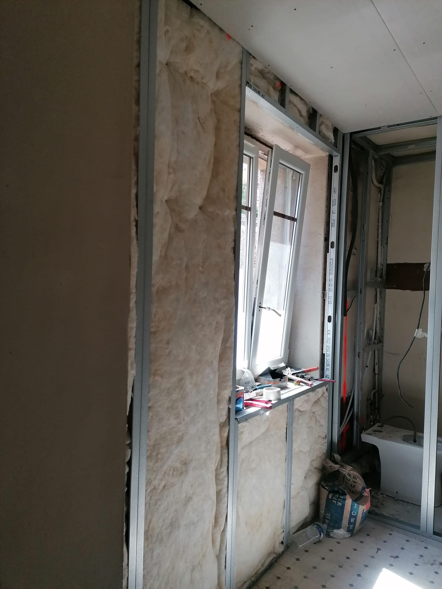 Isolation et ossature de la salle de bains avec fenêtre en cours de rénovation