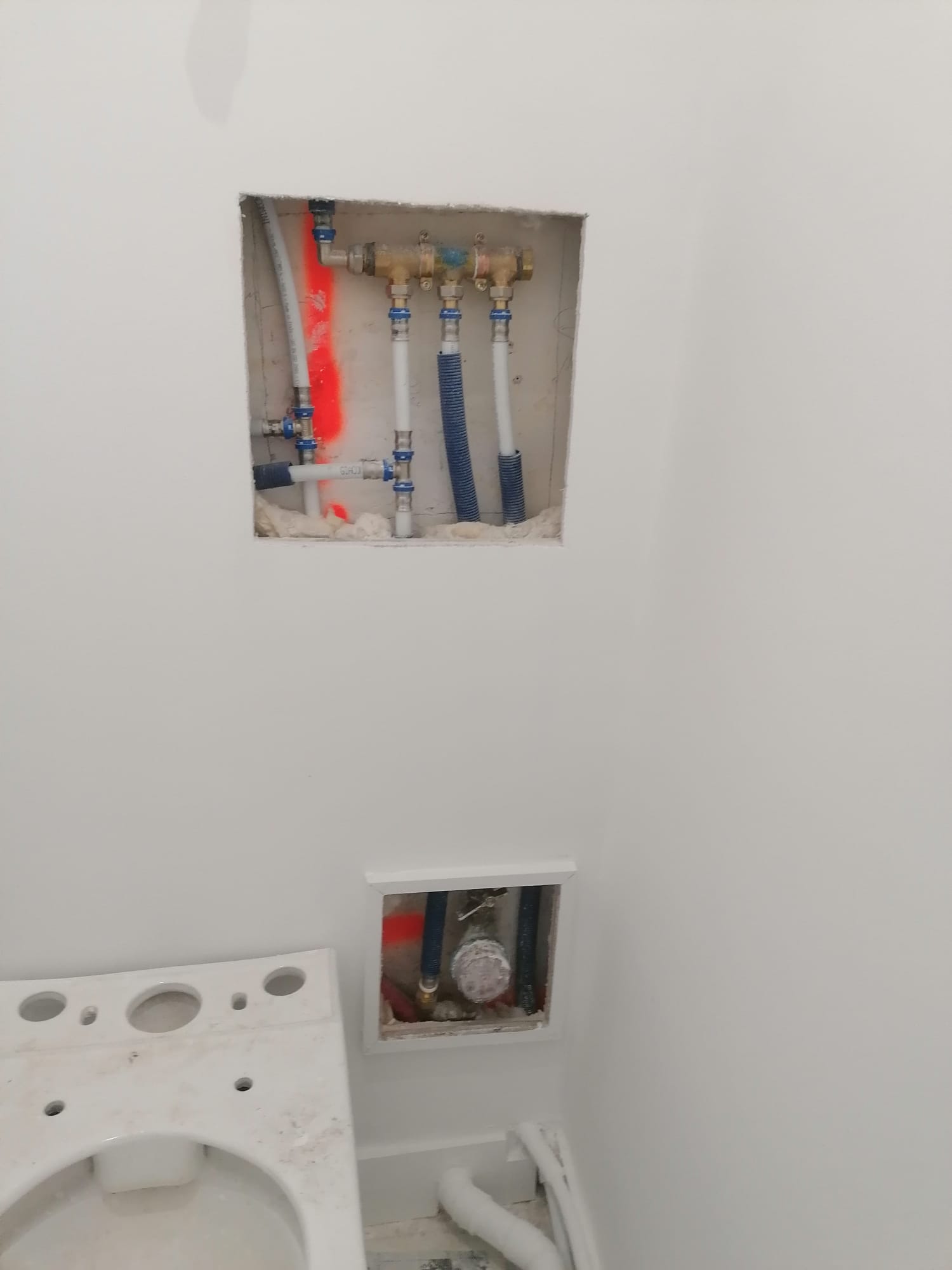 Attentes de plomberie et vannes d'arrêt dans le mur de la salle de bains