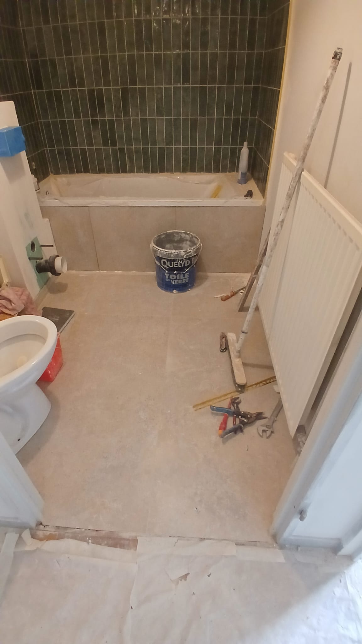 Salle de bains Paris 75017 pendant travaux : carrelage mural et sol en cours de pose