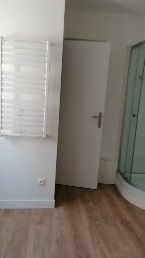 Salle d'eau terminée avec sèche-serviettes et cabine de douche