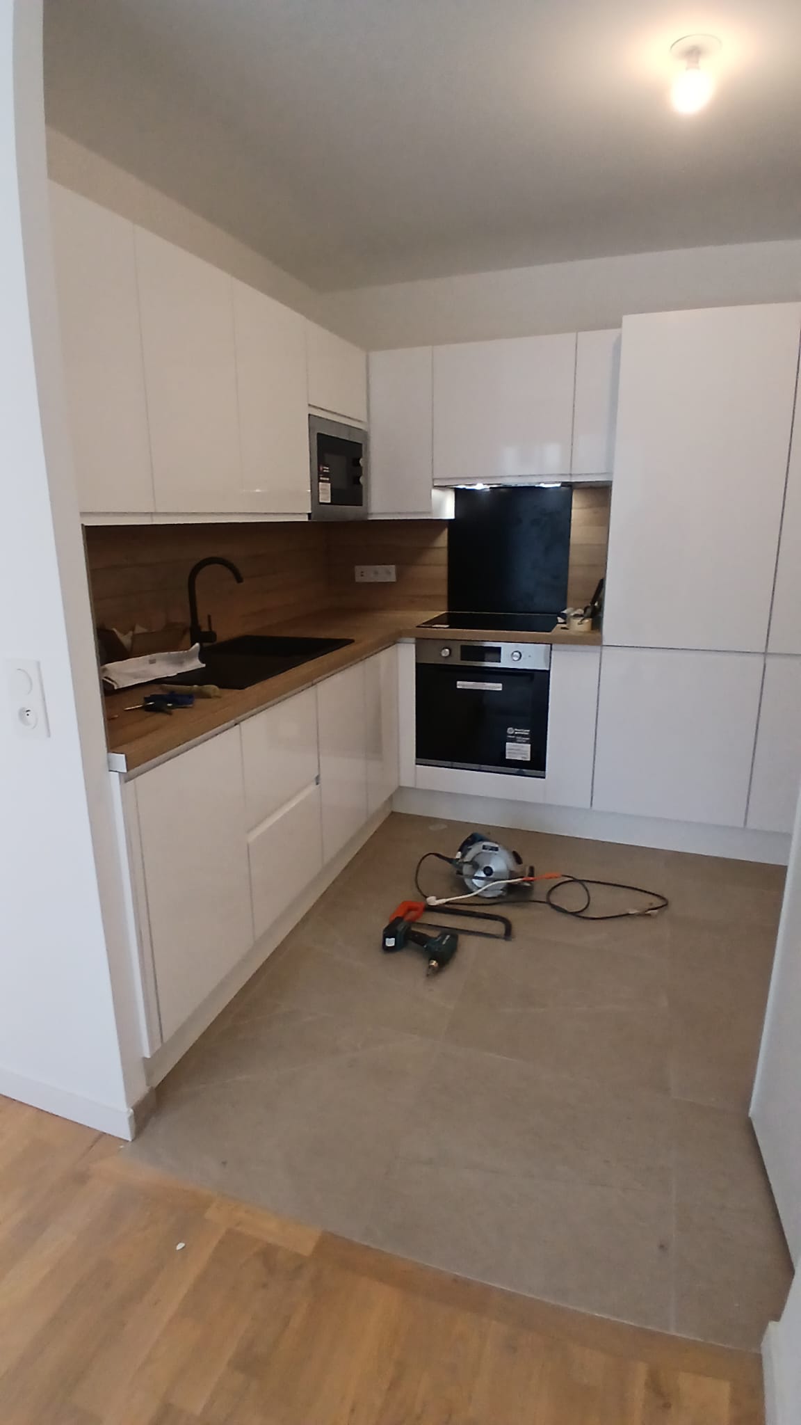 Angle de la cuisine avec four, micro-ondes, plaque induction et colonne de rangement