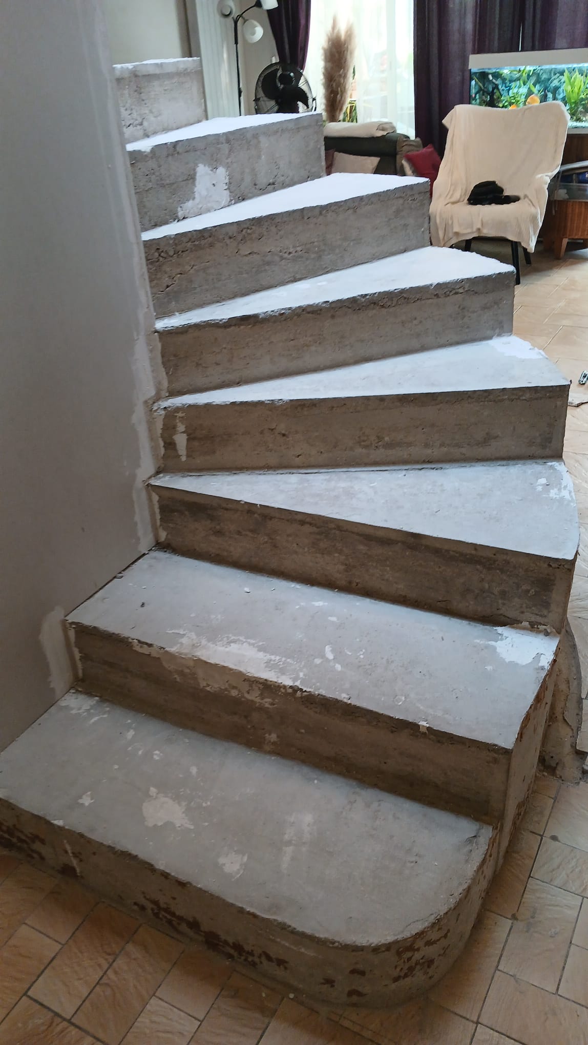 Escalier béton en colimaçon décoffré à 91000 : marches balancées et joue courbe enduite